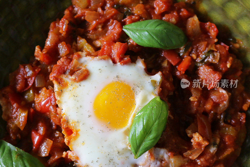 地中海健康早餐shakshouka / shakshuka / chakchouka在一个碗里，鸡蛋煮在西红柿，辣椒，洋葱，橄榄油，大蒜和罗勒酱里。用孜然、红辣椒和胡椒调味的调味汁，配面包食用。